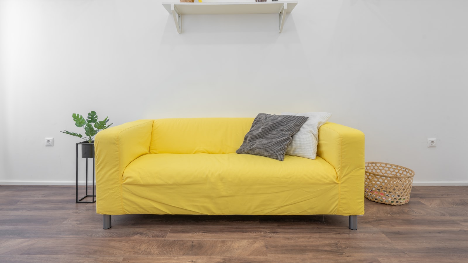 A simple home entryway with wall hooks holding coats and bags.